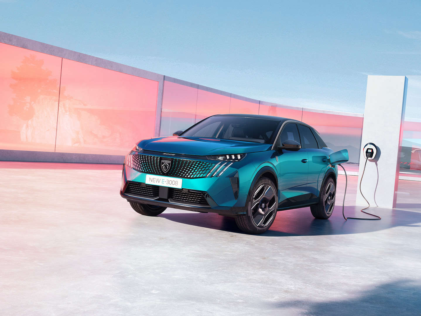 Peugeot e-3008 синього кольору заряджається від електромережі, вигляд спереду з лівого боку