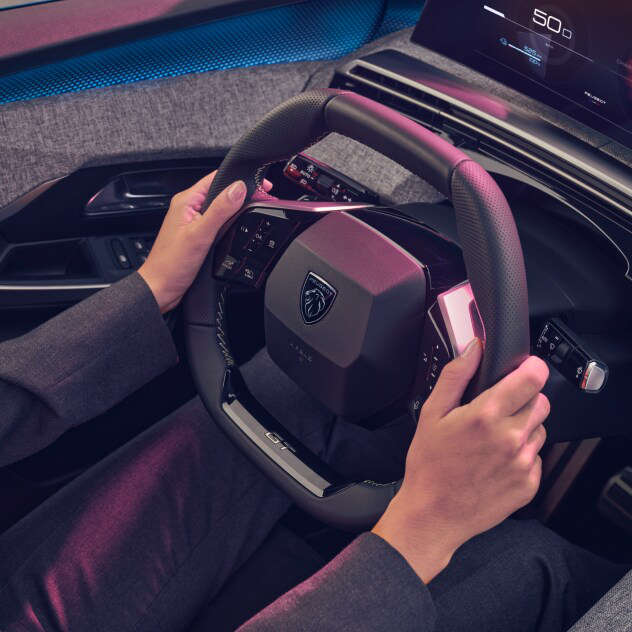 Руки на кермі у салоні нового Peugeot e-3008
